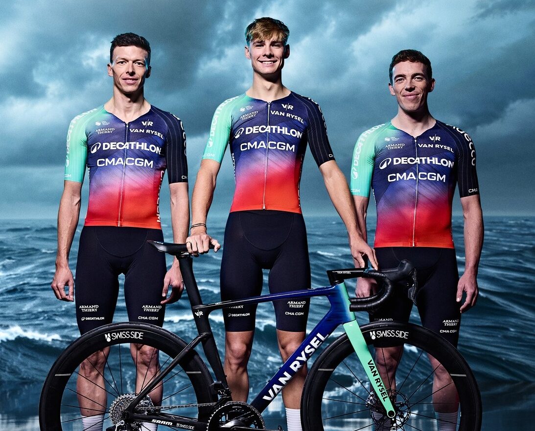 Coureurs de la Decathlon CMA CGM Team portant le nouveau maillot 2026 aux tons bleu, vert et rouge dans un studio.