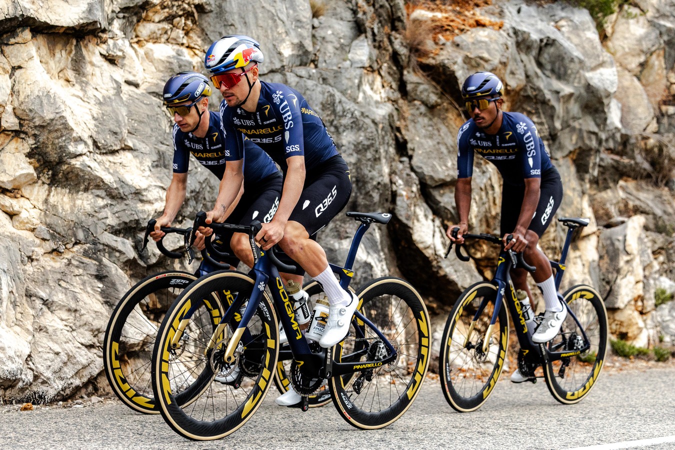Tom Pidcock à l’entraînement avec le Q36.5 Pro Cycling Team sur une route de montagne, lors d’une sortie collective en tenue officielle Pinarello.
