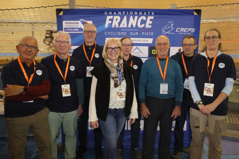 Portrait de Valérie Maret, entourée de bénévoles, au vélodrome de Bourges, lors d’un événement fédéral.