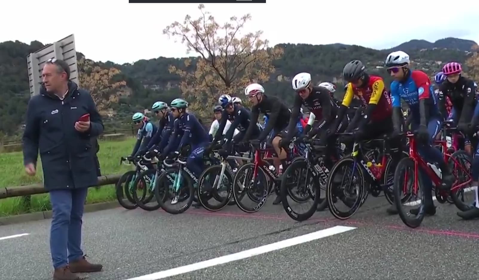 Peloton au départ d’une étape de Paris-Nice sous ciel couvert